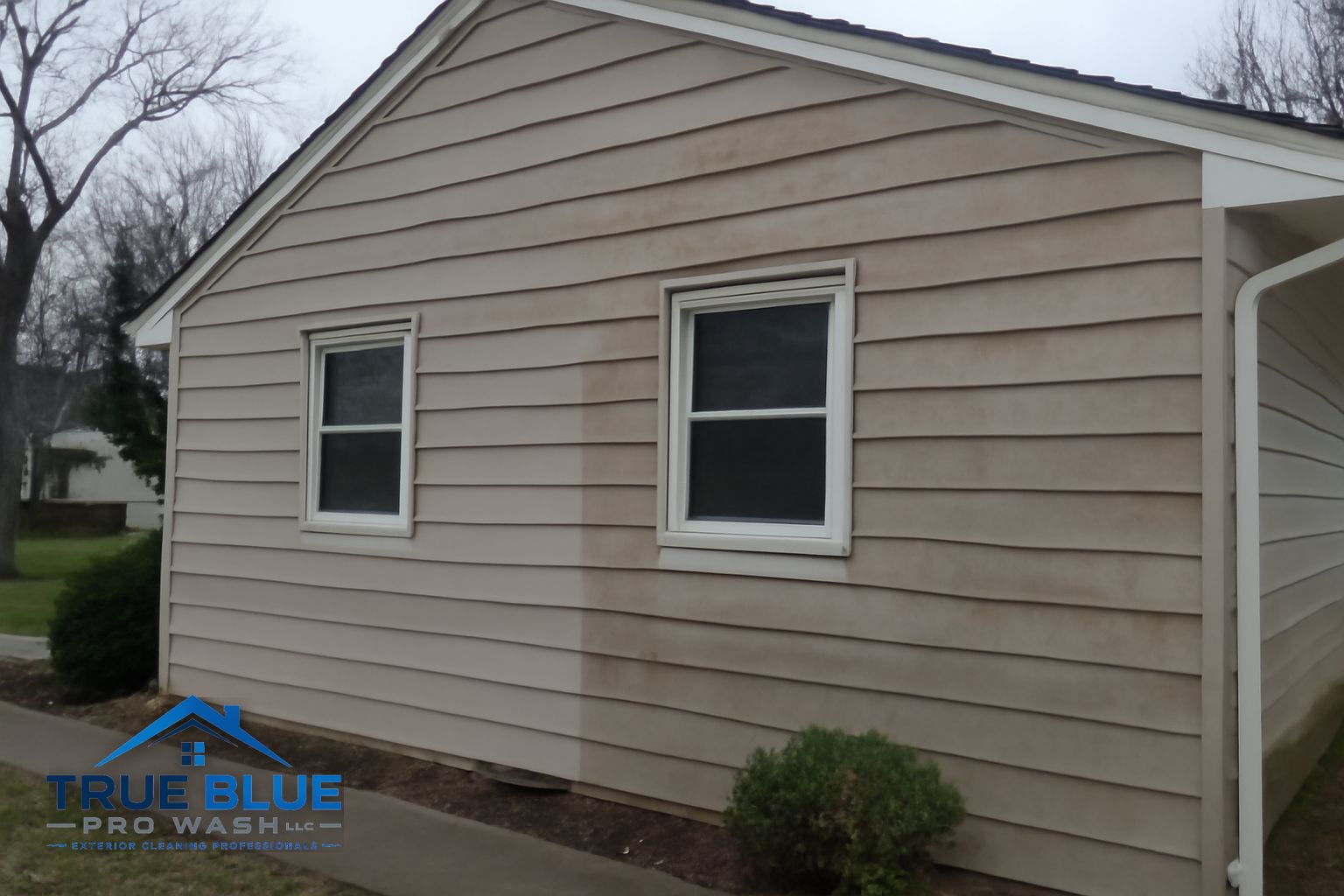 Technician applying soft wash solution to a commercial building exterior in Southeast Pennsylvania