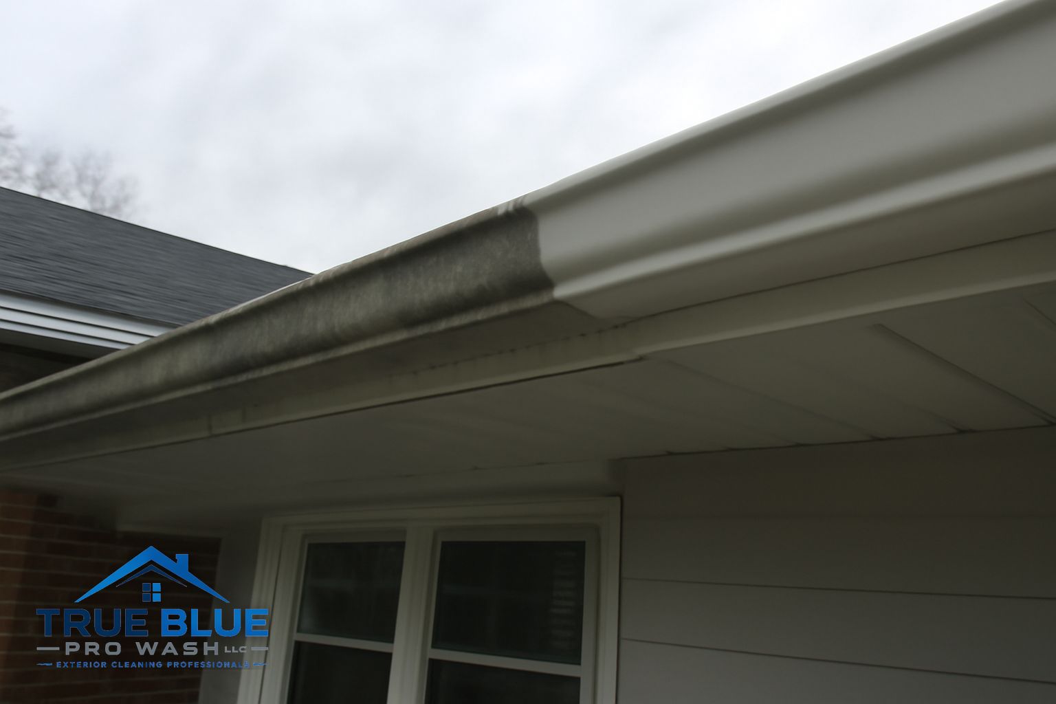 Crew flushing downspouts on a residential property in New Castle Delaware after full gutter cleaning