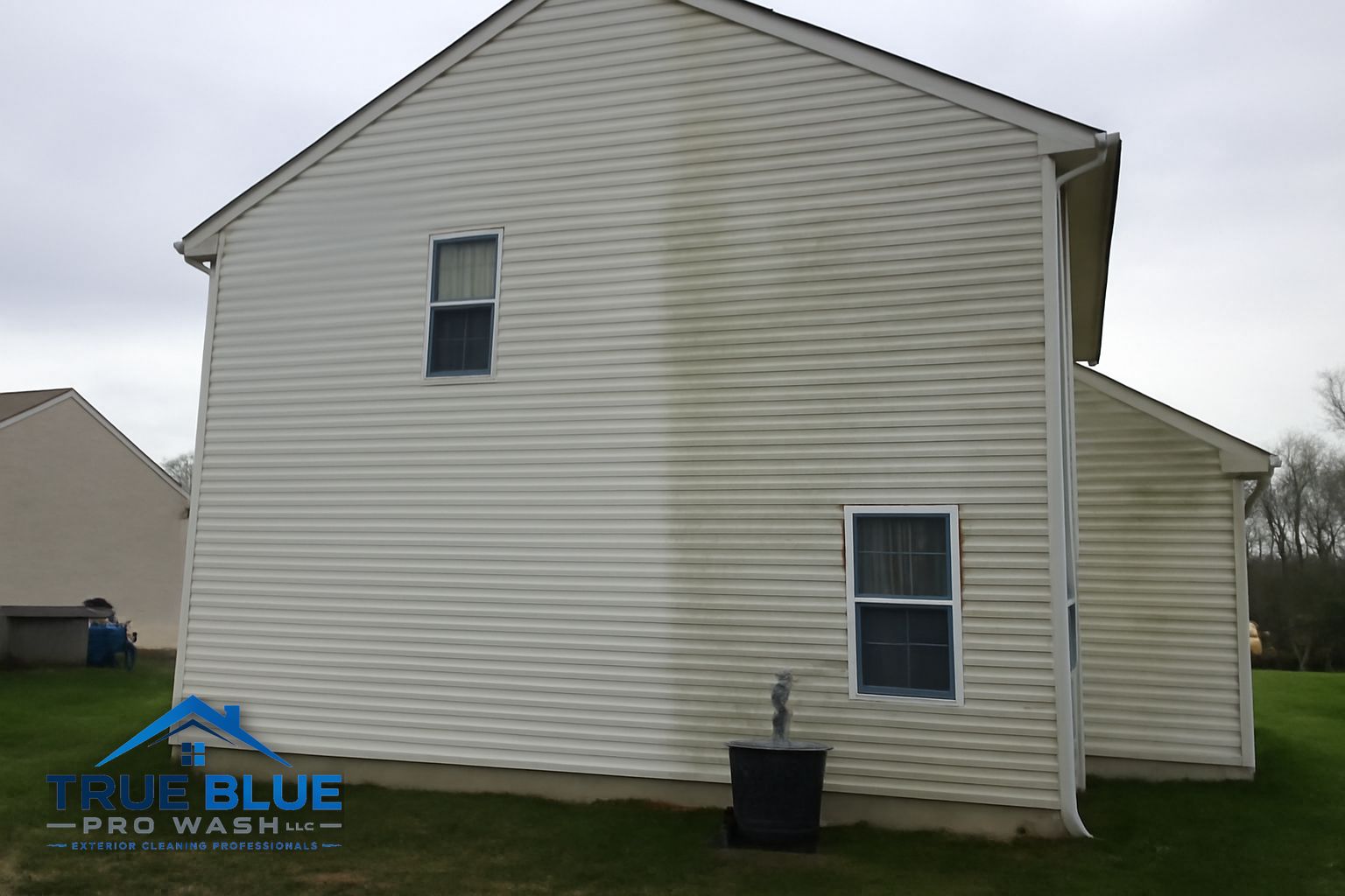 Soft wash technician cleaning siding on a residential home in New Castle County Delaware