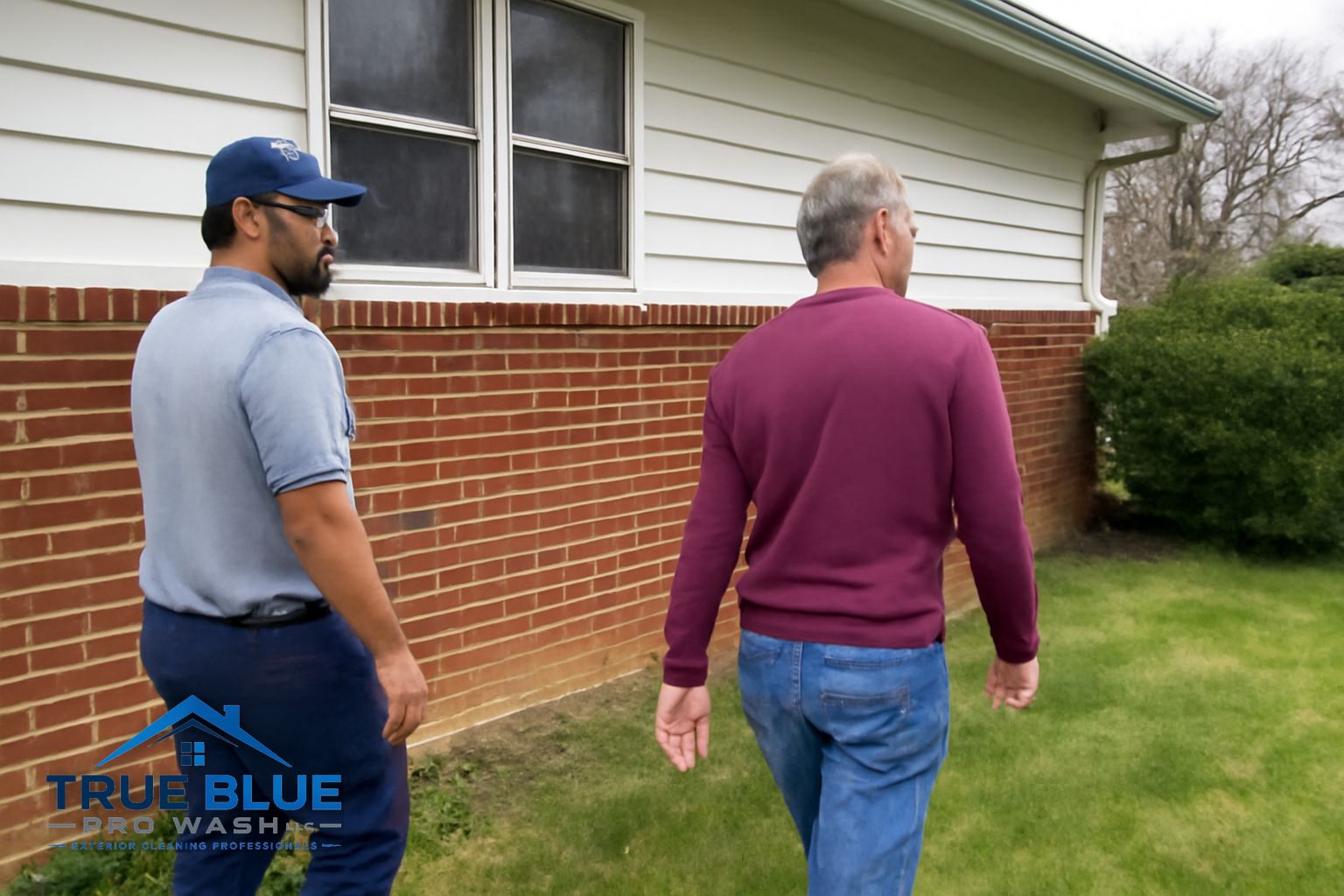 True Blue Pro Wash technician applying soft wash solution to the siding of a two-story home in Wilmington Delaware