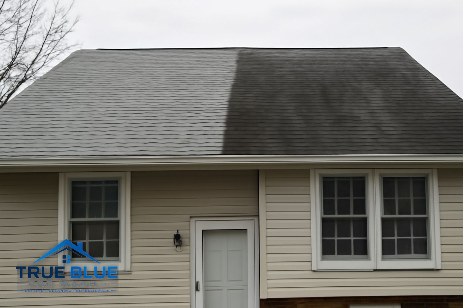 Technician soft washing the side of a home with low pressure in a Delaware residential neighborhood