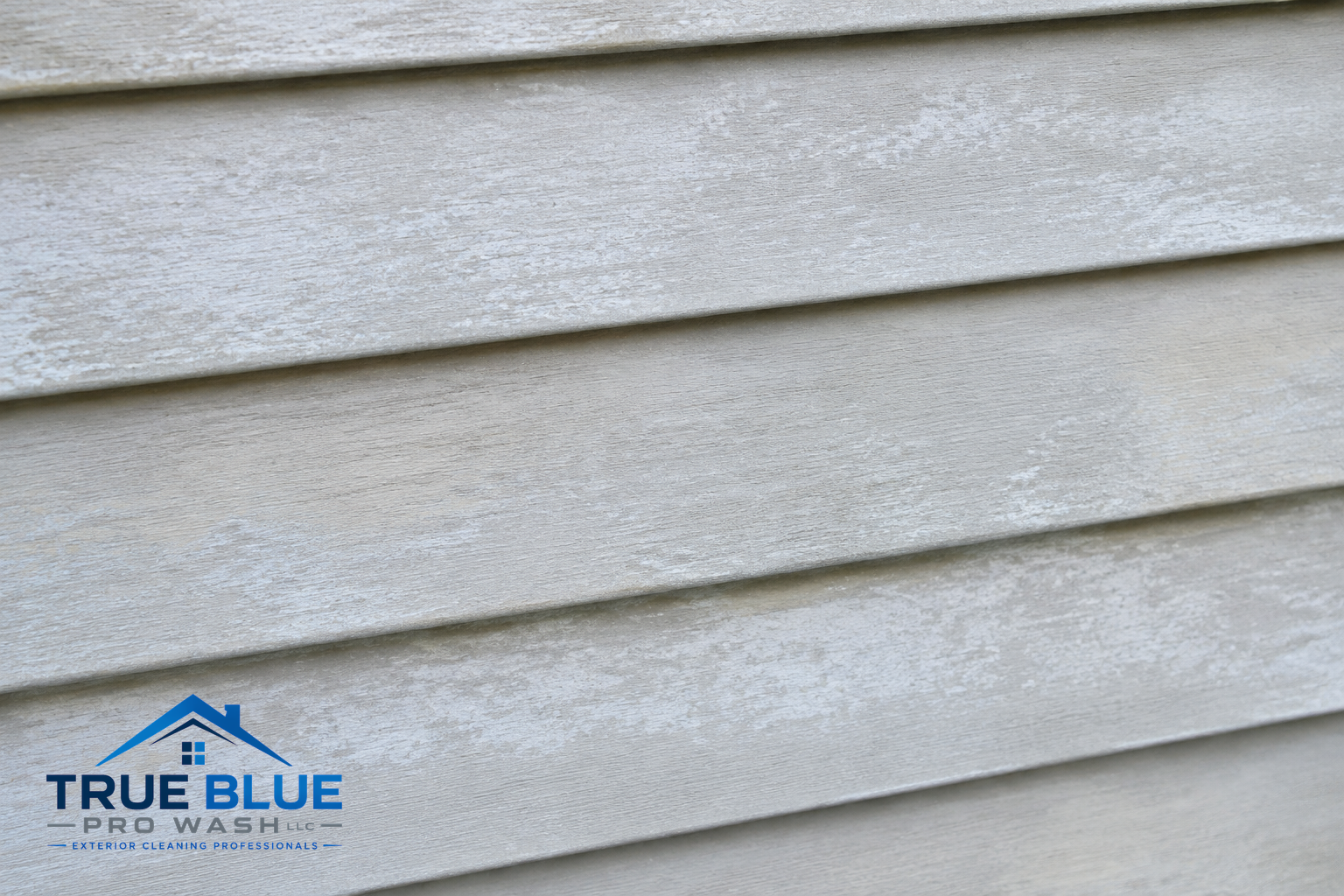 Close-up of faded siding with chalky, powdery residue visible on the surface